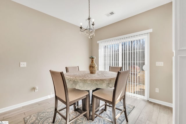 dining room with a chandelier and light wood-type flooring