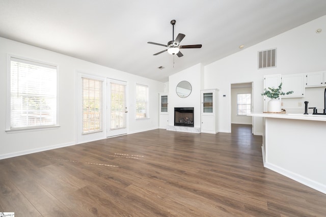 unfurnished living room featuring high vaulted ceiling, ceiling fan, and dark wood-type flooring