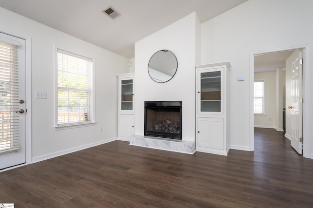 unfurnished living room featuring lofted ceiling and dark hardwood / wood-style floors