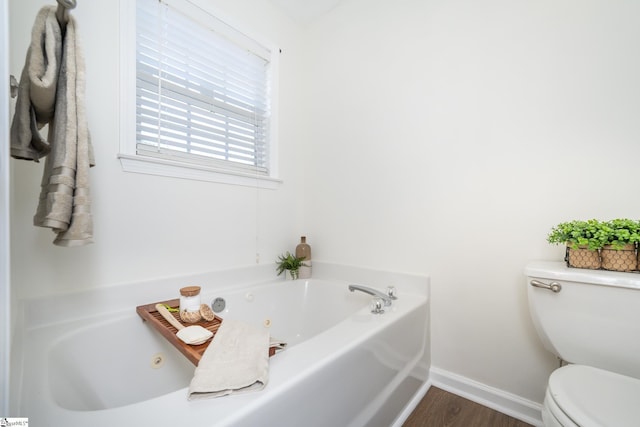 bathroom with a bathtub, hardwood / wood-style floors, and toilet