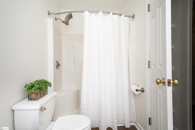 bathroom featuring curtained shower and toilet