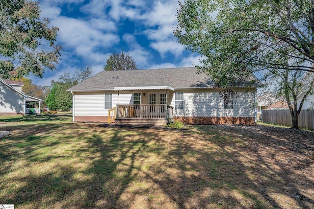 back of property with a deck and a yard