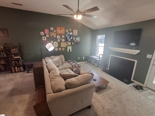 living room featuring carpet floors, ceiling fan, and vaulted ceiling