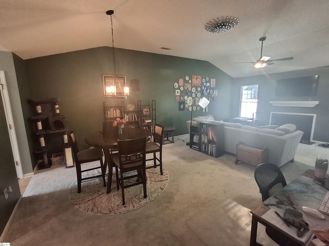 dining space featuring lofted ceiling, ceiling fan with notable chandelier, and light carpet