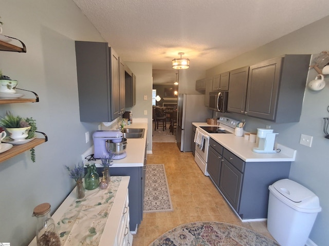 kitchen with stainless steel appliances, a textured ceiling, and sink