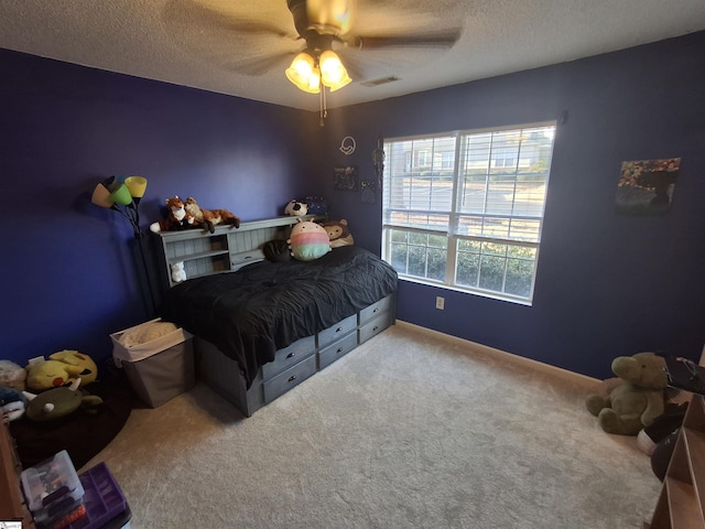 bedroom with a textured ceiling, carpet floors, and ceiling fan