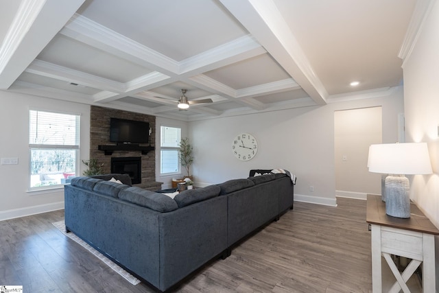 living room with dark hardwood / wood-style flooring, a stone fireplace, ceiling fan, beam ceiling, and coffered ceiling