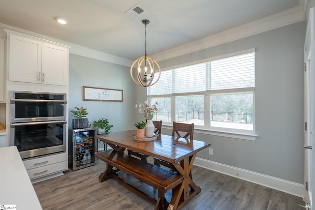 dining room featuring dark wood-type flooring, ornamental molding, beverage cooler, and a chandelier