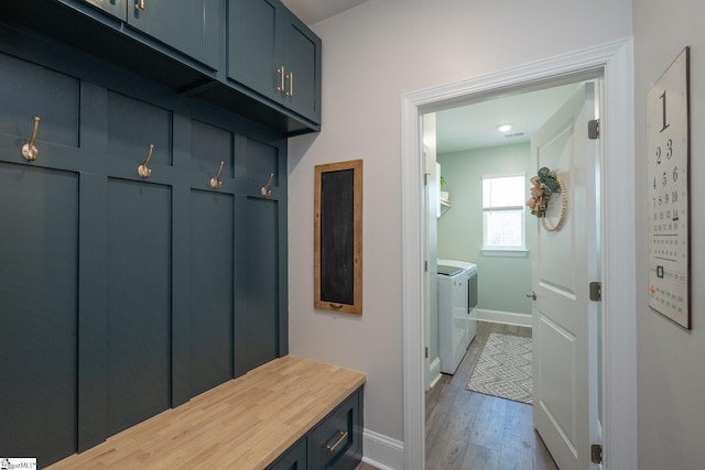 mudroom with hardwood / wood-style flooring and washing machine and clothes dryer