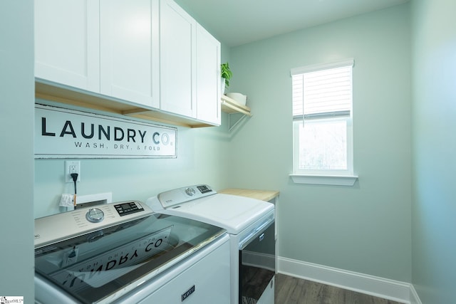 laundry area featuring washing machine and dryer, cabinets, and dark hardwood / wood-style floors