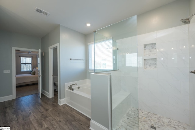 bathroom featuring toilet, independent shower and bath, and hardwood / wood-style floors