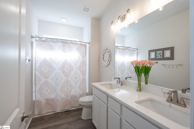 full bathroom featuring hardwood / wood-style flooring, plenty of natural light, toilet, and vanity