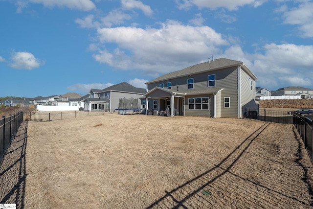 rear view of house featuring a trampoline