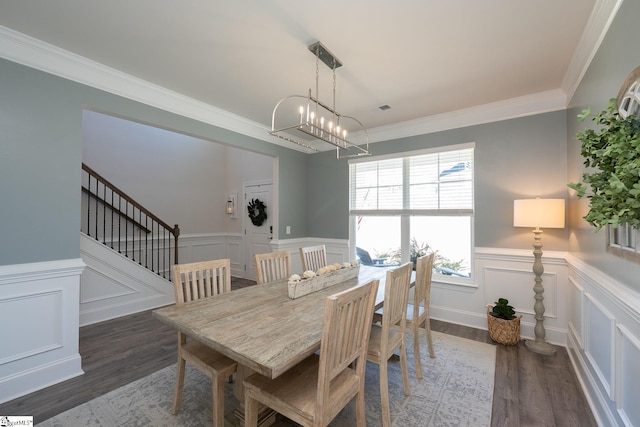 dining area featuring dark hardwood / wood-style floors, ornamental molding, and an inviting chandelier