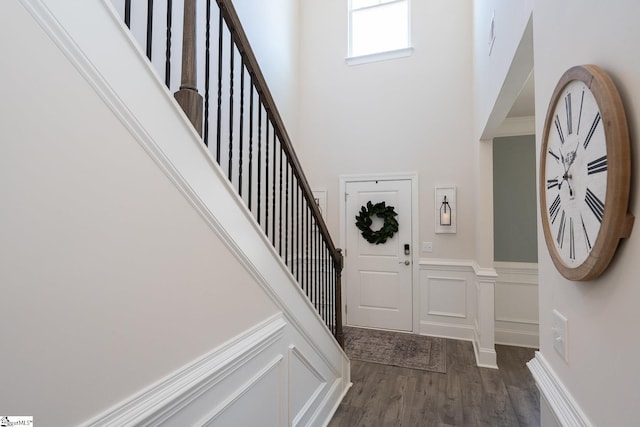 entrance foyer featuring dark hardwood / wood-style flooring and a towering ceiling