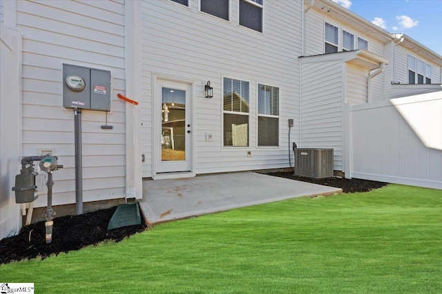 rear view of house featuring a patio, a lawn, and central AC