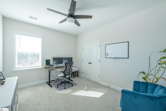 carpeted home office with ceiling fan and plenty of natural light