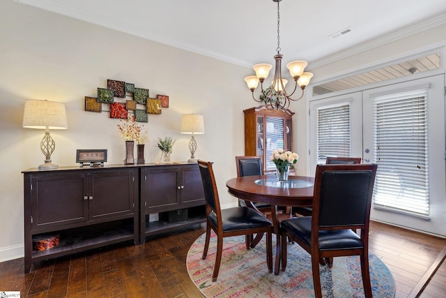 dining space featuring ornamental molding, dark hardwood / wood-style floors, and a notable chandelier