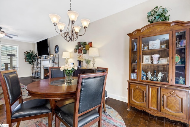 dining area featuring crown molding, dark hardwood / wood-style flooring, and ceiling fan with notable chandelier