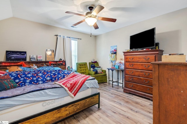 bedroom featuring ceiling fan, light hardwood / wood-style flooring, and vaulted ceiling