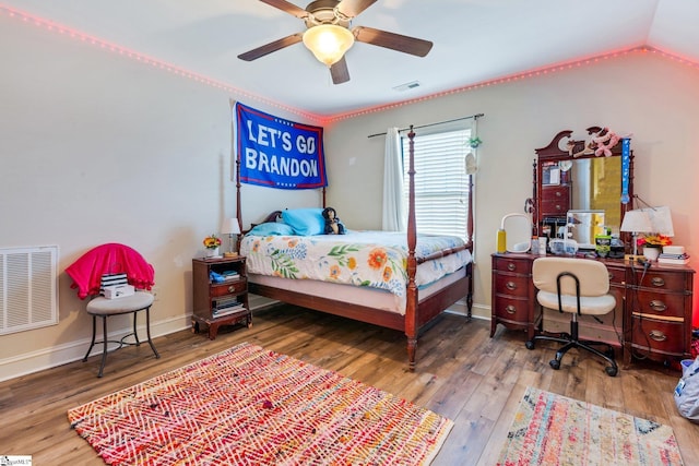 bedroom with ceiling fan, hardwood / wood-style flooring, and lofted ceiling