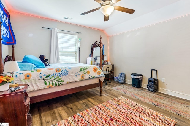 bedroom with ceiling fan, hardwood / wood-style floors, and vaulted ceiling