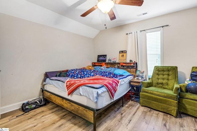 bedroom with ceiling fan, lofted ceiling, and wood-type flooring