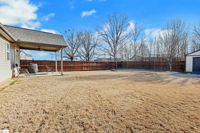 view of yard with ceiling fan, a patio area, and a storage shed