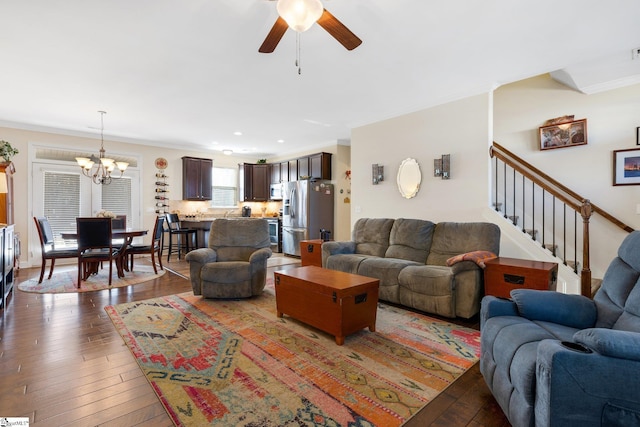 living room featuring crown molding, ceiling fan with notable chandelier, and dark hardwood / wood-style floors