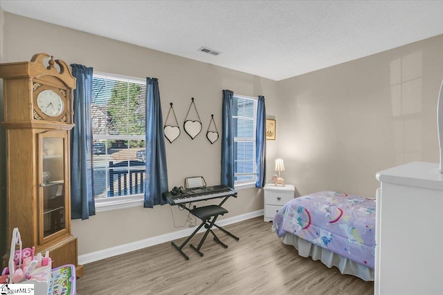 bedroom featuring a textured ceiling and light hardwood / wood-style floors