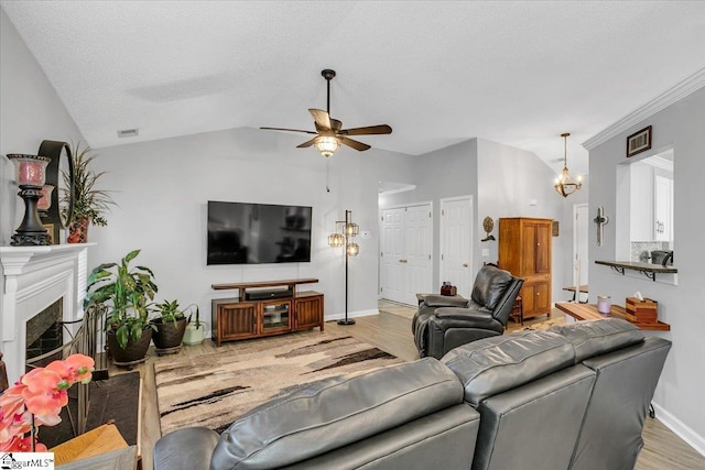 living room with ceiling fan, light wood-type flooring, a textured ceiling, vaulted ceiling, and crown molding