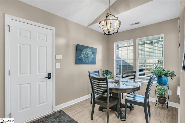 dining room with light hardwood / wood-style flooring and a notable chandelier