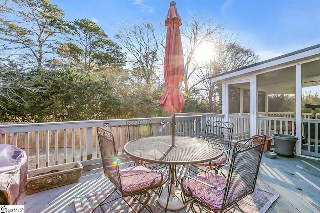 wooden deck with a grill and a sunroom