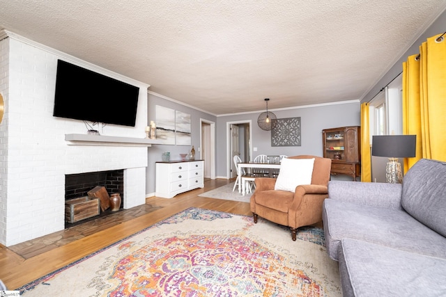 living room with a textured ceiling, ornamental molding, a fireplace, and hardwood / wood-style floors