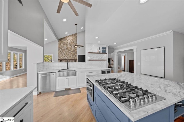 kitchen featuring lofted ceiling, tasteful backsplash, sink, white cabinetry, and appliances with stainless steel finishes