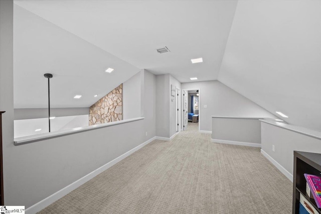 additional living space featuring lofted ceiling and light colored carpet