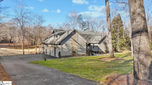 view of side of property featuring a garage and a yard