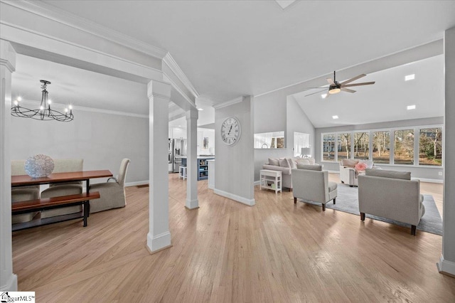 living room featuring decorative columns, light wood-type flooring, vaulted ceiling, crown molding, and ceiling fan with notable chandelier