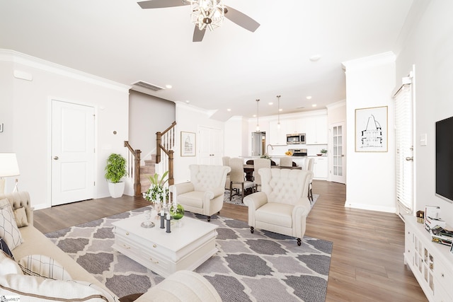 living room featuring ceiling fan, hardwood / wood-style floors, and crown molding