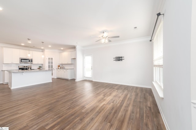 unfurnished living room featuring ceiling fan, crown molding, dark hardwood / wood-style floors, and sink