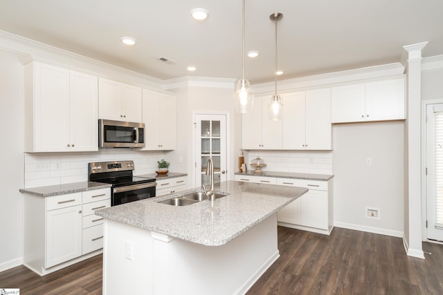 kitchen featuring appliances with stainless steel finishes, a kitchen island with sink, decorative light fixtures, white cabinets, and sink