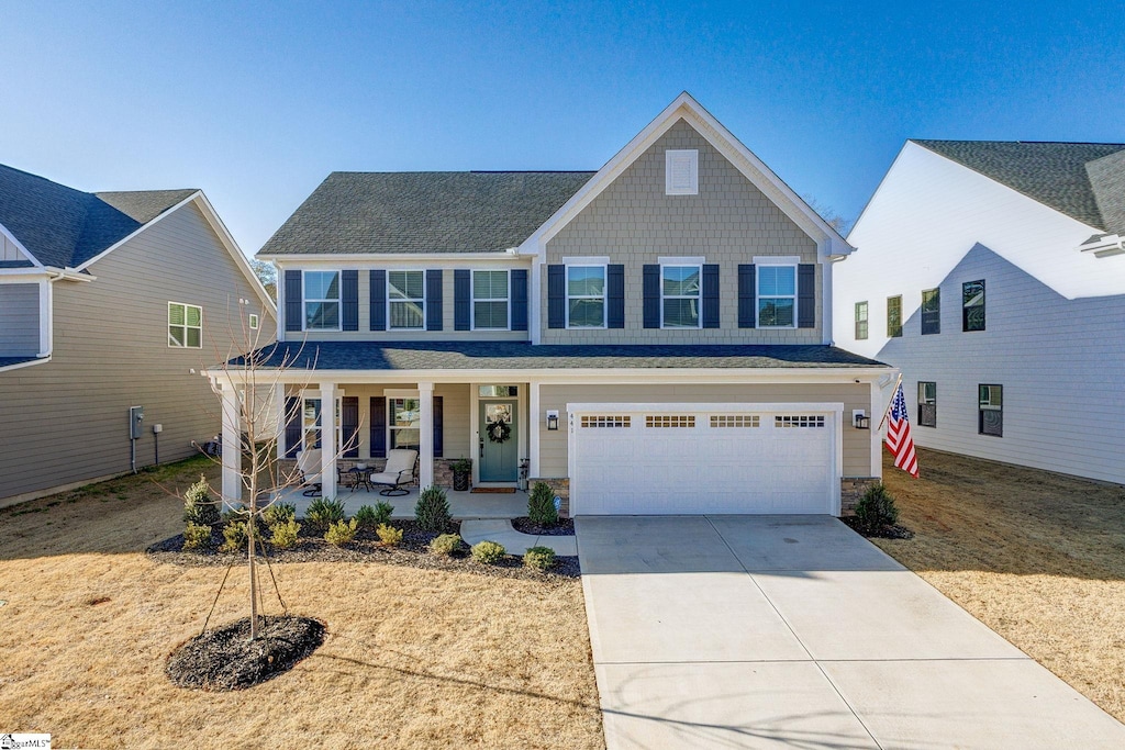 view of front of property with covered porch and a garage