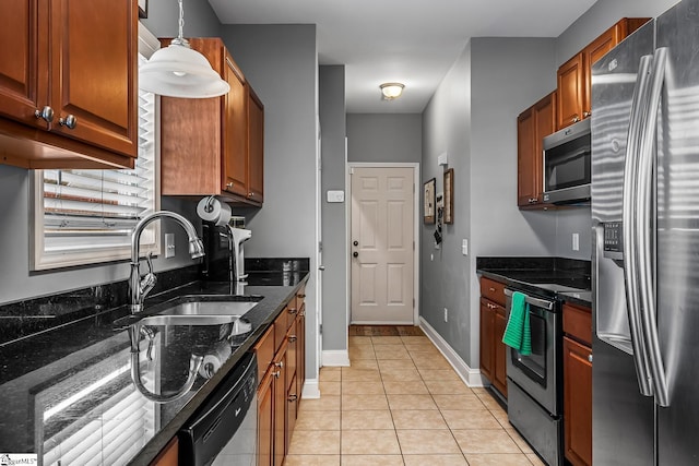 kitchen with light tile patterned floors, stainless steel appliances, dark stone counters, pendant lighting, and sink