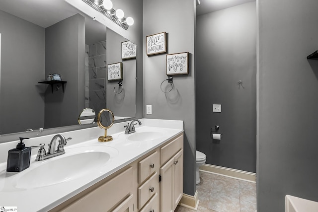 bathroom with toilet, tile patterned floors, and vanity