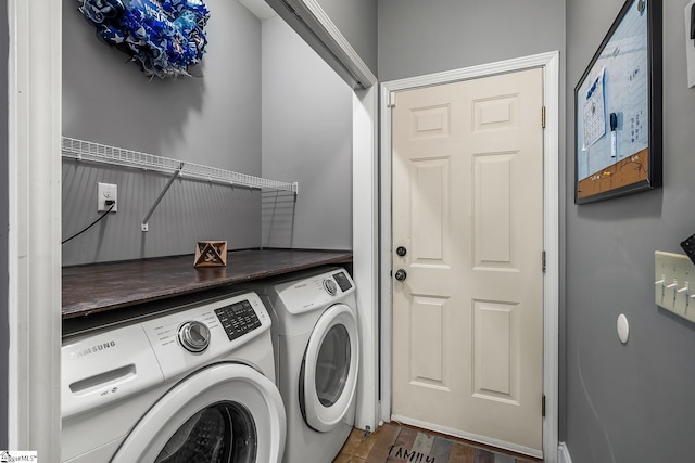 clothes washing area with dark hardwood / wood-style flooring and washer and dryer