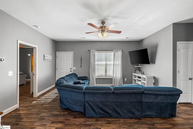 living room with ceiling fan and dark hardwood / wood-style flooring