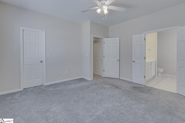 unfurnished bedroom featuring light carpet, ceiling fan, and ensuite bath