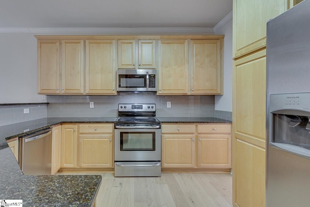 kitchen with appliances with stainless steel finishes, crown molding, dark stone countertops, and backsplash