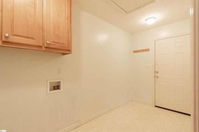 laundry area with washer hookup, cabinets, and a textured ceiling