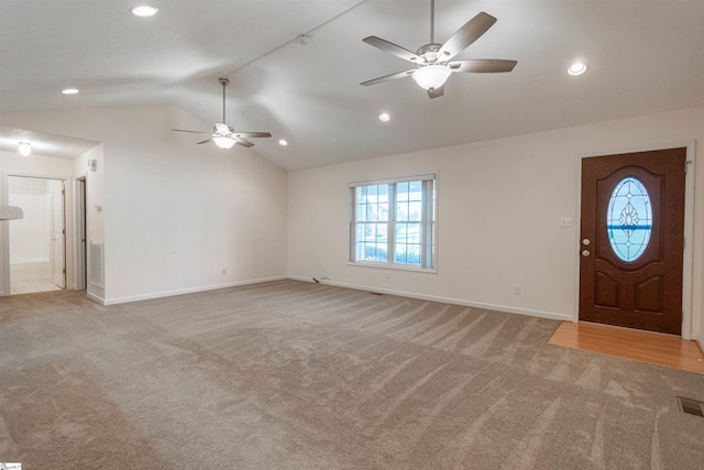 foyer featuring ceiling fan, light colored carpet, and vaulted ceiling